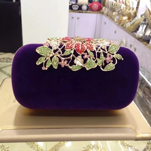 Detail view of purple velvet evening clutch with sparkling crystal floral metal top closure