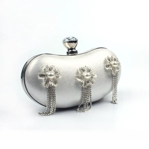 Detail of silver crescent clutch with rhinestone flowers, pearls, and crystal tassel