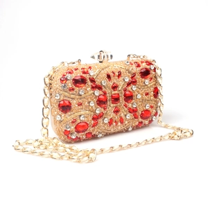 Detailed view of red crystal evening clutch with pearl handle and ornate gemstone clasp