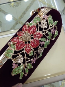 Close-up of velvet evening bag featuring intricate crystal leaf and flower patterns