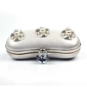 Close-up of glitter silver clutch with snowflake diamond and pearl crystal ornaments