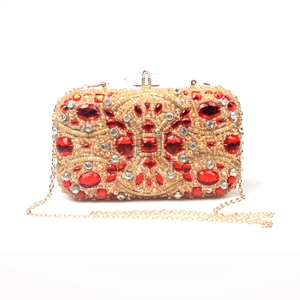 Detailed view of the luxury gold evening clutch with red crystals and beaded pattern