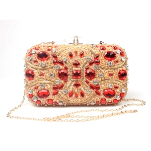 Macro detail of luxury evening clutch with red rubies and gold crystals hand-beaded design