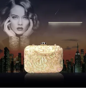 Close-up of champagne evening clutch with detailed floral embroidery and jewel clasp