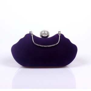 Close-up of luxury purple velvet evening bag with diamond-encrusted ball clasp and handle