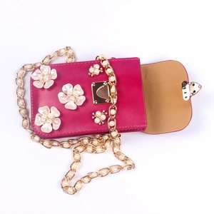 Detailansicht der rosefarbenen Tasche mit Perlenblumen und goldener Herzschließe