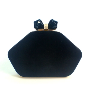 Detail of black velvet evening clutch with sparkling crystal bow clasp and rhinestone ring