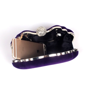 Detail view of purple velvet clutch interior showing storage capacity for a smartphone