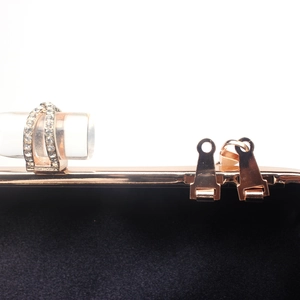 Macro detail of rose gold frame with double-row crystal studs and premium black lining
