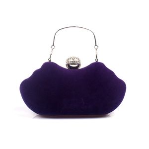 Detail of purple velvet lip-shaped clutch with silver handle and rhinestone clasp decoration