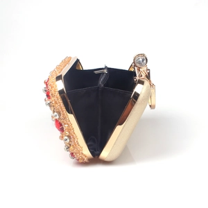 Detail view of gold evening clutch with red crystals and black fabric lining interior