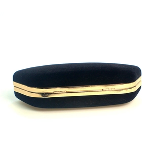 Detail of black velvet eyeglass case with elegant gold metal frame and secure closure