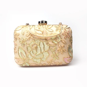 Detailed close-up of champagne evening bag with intricate rose floral embroidery and gold clasp