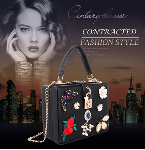 Detail of black evening bag featuring butterfly embroidery, pearls, and crystals