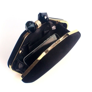 Internal detail of black velvet evening bag showing inner pocket and phone capacity