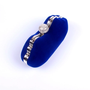Close-up of royal blue velvet evening clutch featuring a crystal-studded spherical clasp