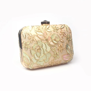 Detailed view of floral embroidery clutch bag with metallic frame and gem-shaped clasp