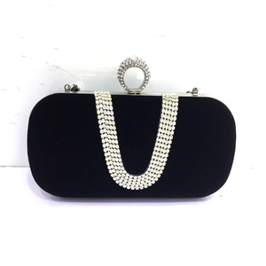 Close-up of black velvet evening bag featuring U-shaped rhinestone tassels and ring clasp