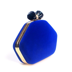 Detail view of royal blue velvet evening clutch with hexagonal frame and crystal clasp