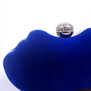Macro shot of navy blue velvet evening bag featuring crystal-studded silver metal clasp