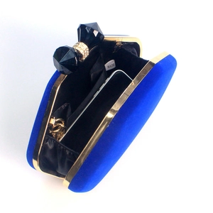 Detail view of royal blue velvet evening clutch interior with gold frame and gem closure