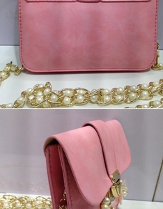 Dettaglio di borsa a tracolla rosa in similpelle con catena dorata e perle