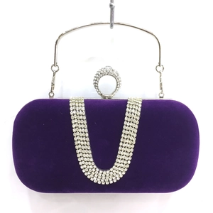 Detail of purple velvet evening clutch with U-shaped rhinestone pattern and ring closure
