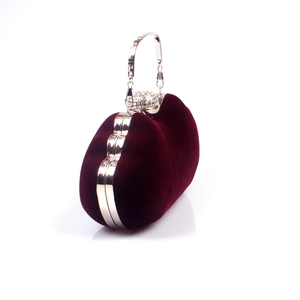 Close-up of burgundy velvet evening bag with crystal encrusted spherical clasp and chain