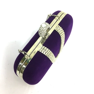 Detail of purple velvet evening clutch with silver rhinestone bands and diamond ring clasp