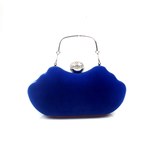 Detail of blue velvet evening bag featuring wave-shaped lip design and crystal buckle