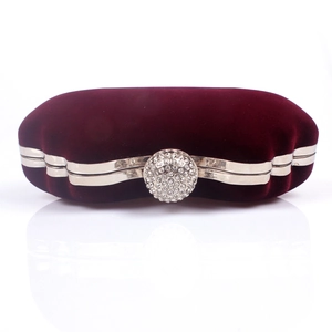 Detailed close-up of velvet clutch with rhinestone clasp and silver metal frame