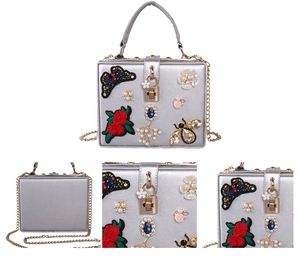 Detail of silver evening bag with butterfly embroidery, 3D roses and gemstone accents