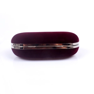 Close-up of elegant burgundy velvet clutch bag with silver metal trim and hinge detail