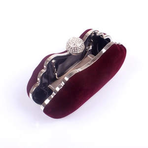 Macro view of burgundy velvet clutch interior with silver metal frame and rhinestone clasp