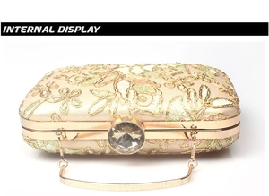 Detail of champagne gold satin clutch with floral embroidery and crystal clasp