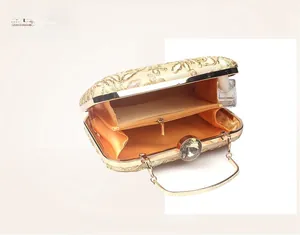Detail view showing champagne gold evening bag interior with zipper pocket and floral embroidery
