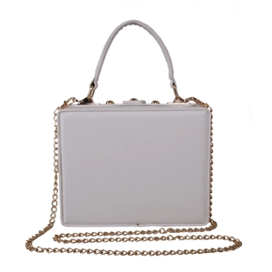 Macro shot of white box bag featuring golden metal hinges and a smooth leather handle