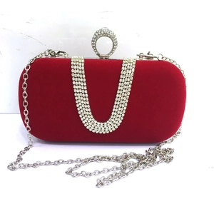 Detail of red velvet evening clutch with U-shaped rhinestone fringe and ring clasp
