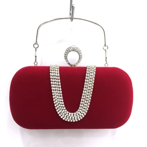 Detailed view of red velvet evening clutch featuring U-shaped rhinestone tassel fringe