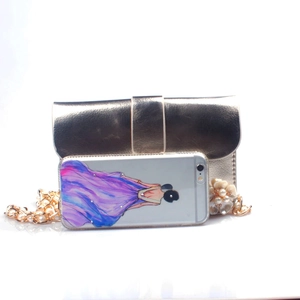 Dettaglio mini borsa dorata con ciondolo a fiori di perle e tracolla a catena spessa
