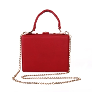 Detail of red square box clutch with gold metal hardware and detachable chain strap