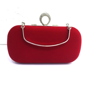 Macro view of red velvet evening bag with crystal encrusted ring handle and silver strap