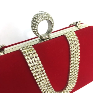 Detail of red velvet evening bag featuring silver metal frame and crystal encrusted ring buckle