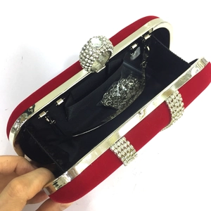 Detail of red velvet evening clutch with gold frame, rhinestone clasp and chain strap