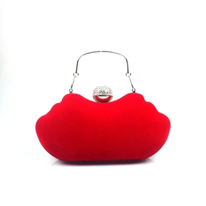 Macro detail of red velvet lip-shaped clutch bag with silver rhinestone lock