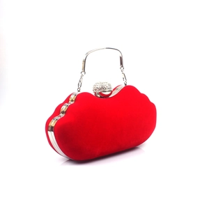 Macro detail of red velvet lips-shaped evening clutch with crystal sphere clasp and silver handle