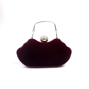 Detail view of burgundy velvet evening bag with silver ring handle and crystal ball clasp