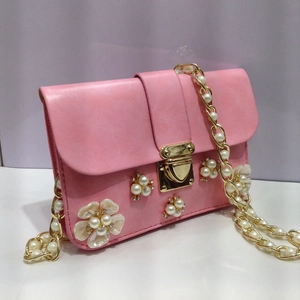Dettaglio borsa a tracolla in PU rosa con fiori di perle e catena dorata
