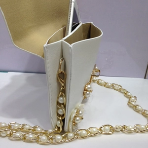Dettaglio borsa porta cellulare in pelle PU bianca con fiori di perle e catena dorata