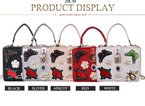 Detailed embroidery with pearl flowers and jewel accents on an elegant evening clutch bag
